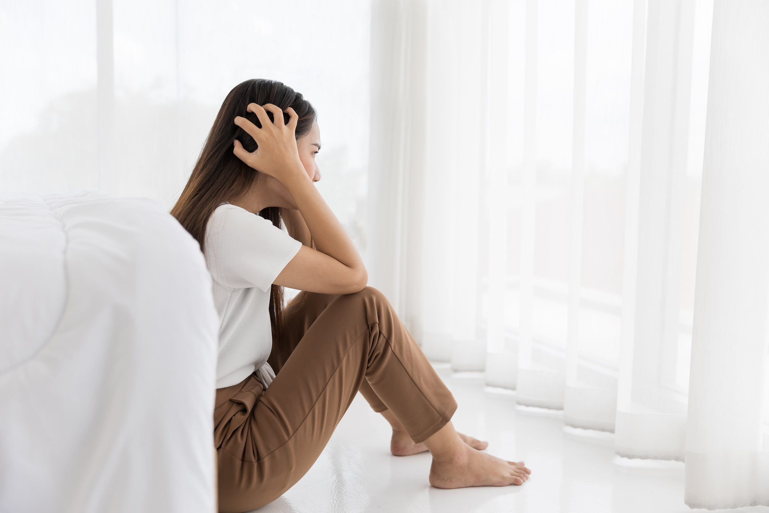 Asian young woman sitting looking at window with stress and Anxiety