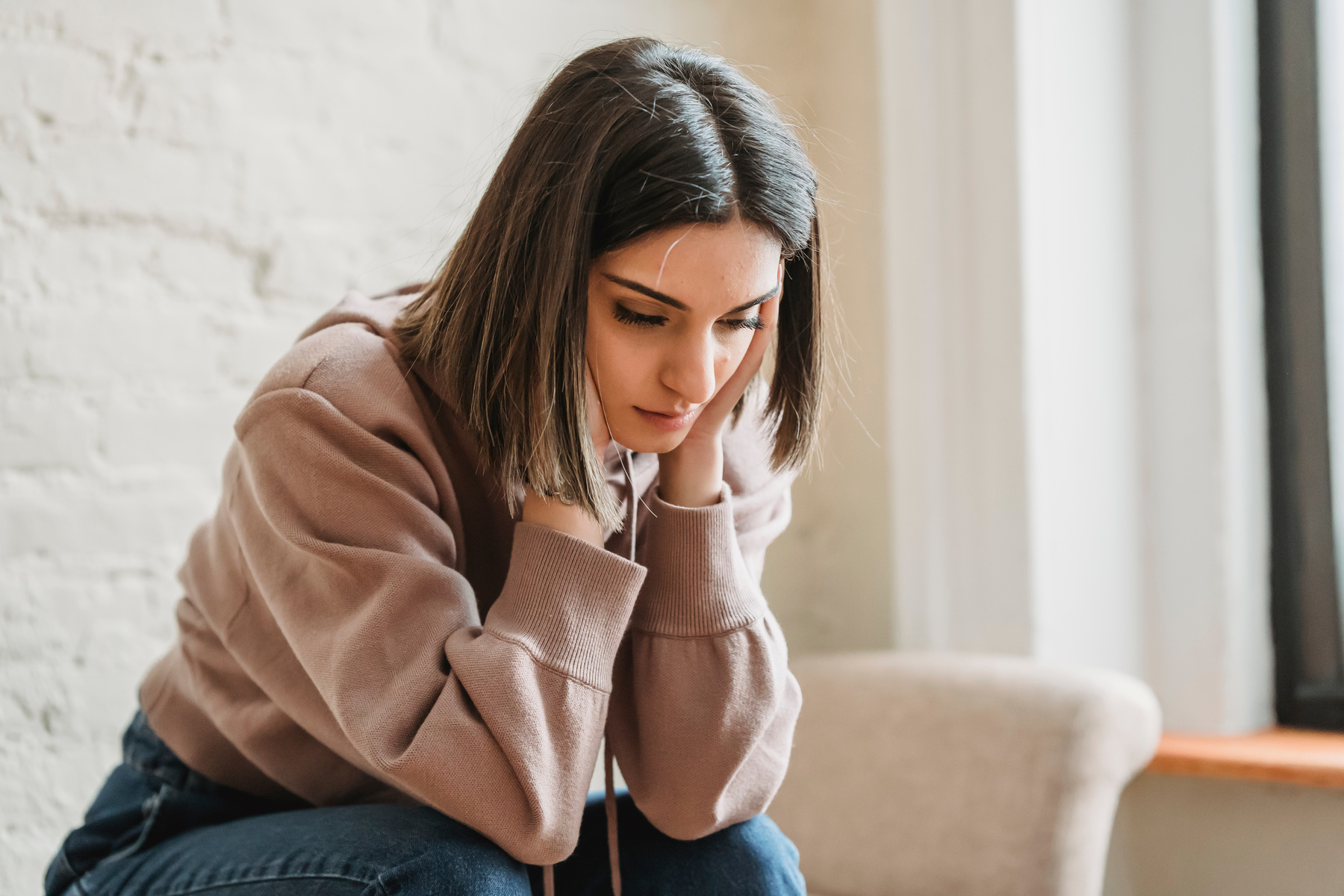 Sad woman sitting on couch